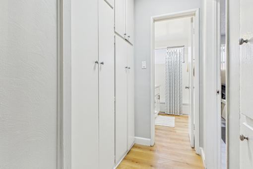A white hallway with a doorway leading to a bathroom.