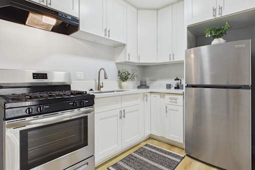 A modern kitchen with white cabinets and stainless steel appliances.