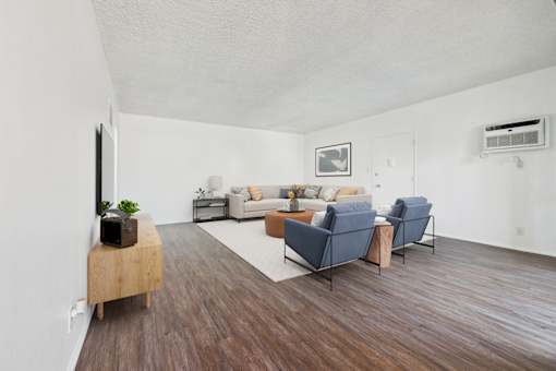 A living room with a wooden floor and a white wall.