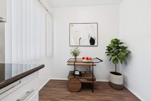 A small table with a plant on it sits in a corner of a room.