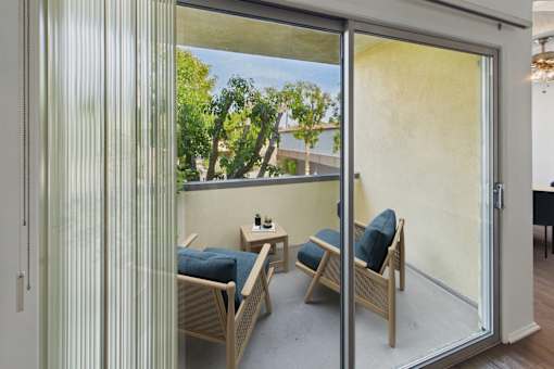 A patio with a table and chairs is visible through a sliding glass door.