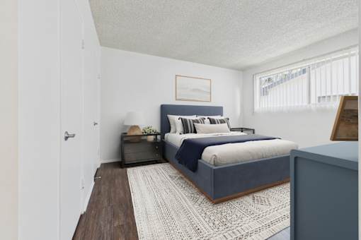 A bedroom with a bed, nightstand, and a rug.