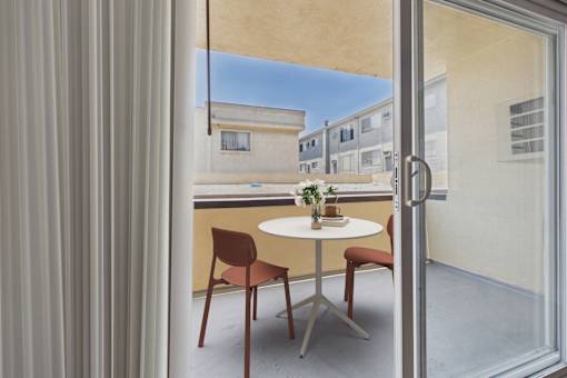 A table with chairs is set up on a balcony.