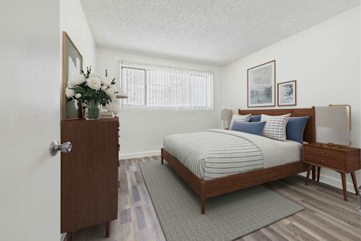 A bedroom with a bed, nightstand, and a wooden door.