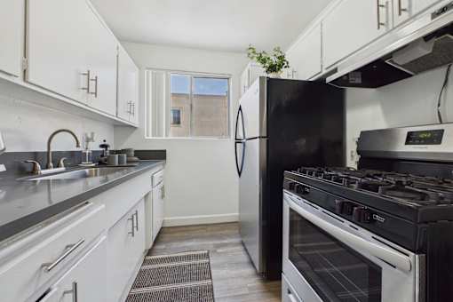 A kitchen with a black refrigerator and stove.