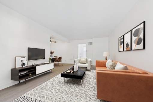 A living room with a brown couch, a coffee table, and a television.