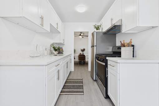 A kitchen with white cabinets and appliances.