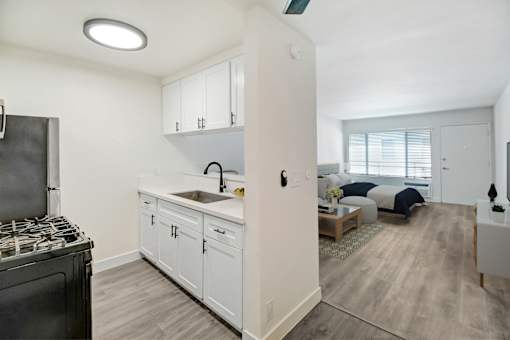 an open kitchen and living room with a stove and a window