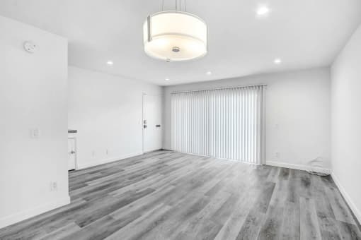 an empty living room with white walls and wood flooring