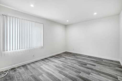 an empty room with white walls and a window with white blinds