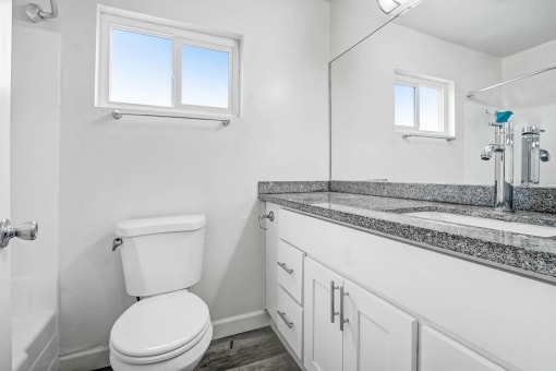 a white bathroom with a toilet and a sink