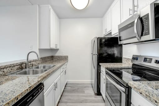 a kitchen with granite counter tops and stainless steel appliances