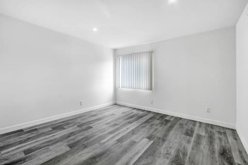 an empty living room with white walls and wood flooring