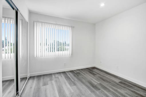 an empty bedroom with a window and a sliding glass door