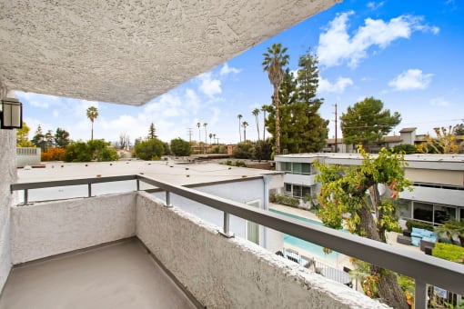 the view from the balcony of a condo with a pool and trees