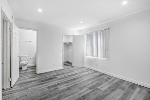 a renovated living room with white walls and wood flooring