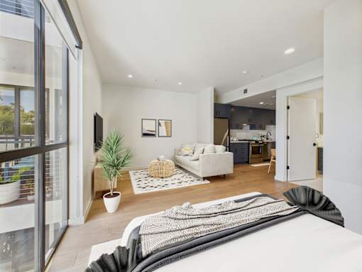 A modern living room with a large window and a white couch.