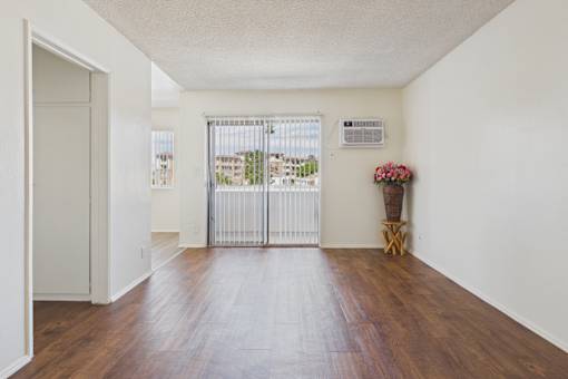 A white room with a wooden floor and a white door.