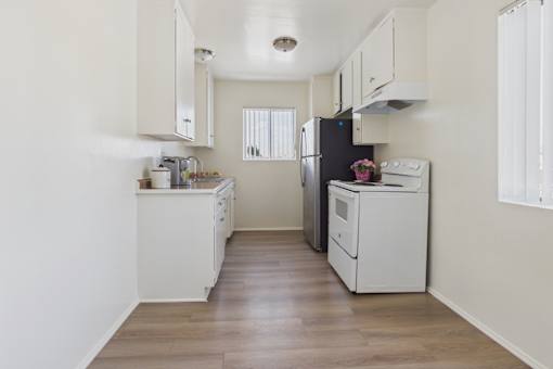 A kitchen with white cabinets and appliances.