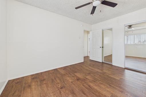 A room with wooden floors and a ceiling fan.
