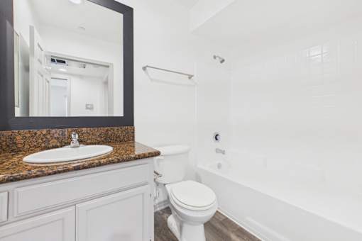 A white toilet sits next to a sink in a bathroom.