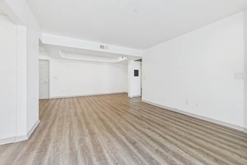 A room with wooden flooring and white walls.