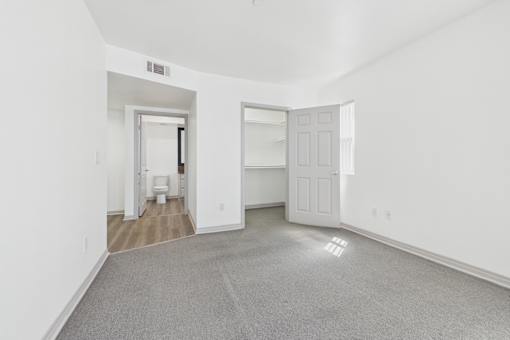 A large empty room with a carpeted floor and white walls.