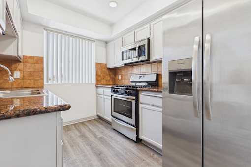 A modern kitchen with stainless steel appliances and white cabinets.