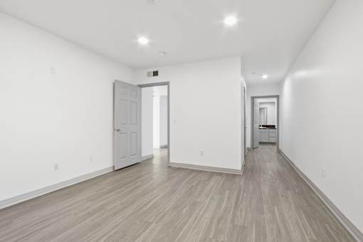 A long hallway with a white door at the end.