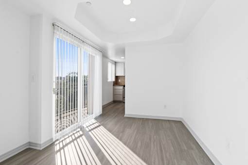 A room with a sliding glass door leading to a balcony.