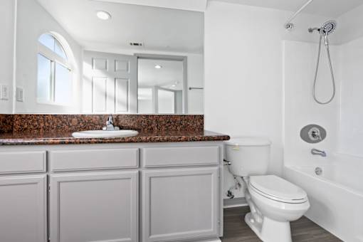 A white toilet sits next to a shower in a bathroom.