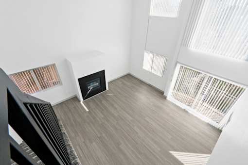 A modern living room with a fireplace and a staircase.