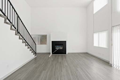 A modern living room with a fireplace and a staircase.