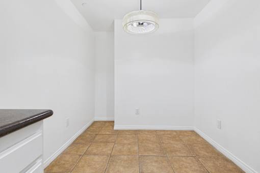 A room with a brown tile floor and white walls.