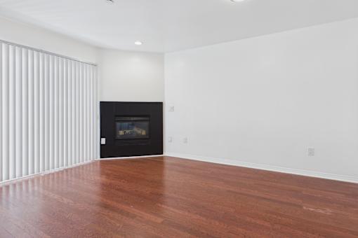 A room with a fireplace and wooden floors.