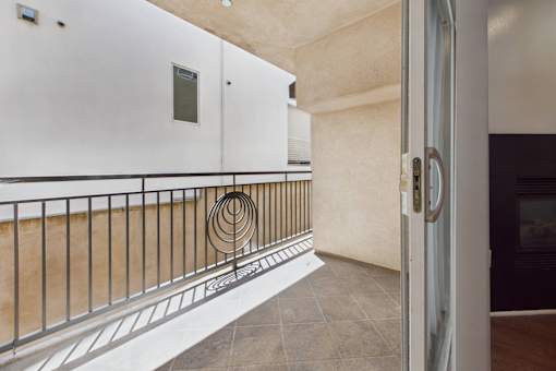 A balcony with a metal railing and a white door.