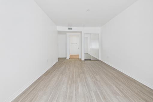 A room with a white wall and a wooden floor.