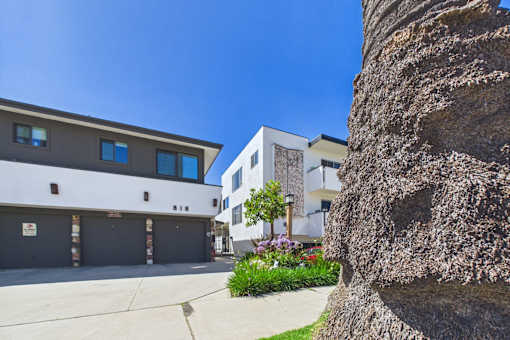 A large rock is in the foreground of a building with a garage door.