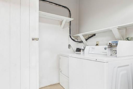 A white washing machine with a dryer on top of it.
