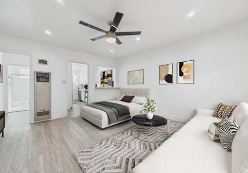 A modern bedroom with a large bed, a couch, and a ceiling fan.