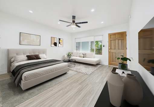 A modern bedroom with a large bed and a ceiling fan.