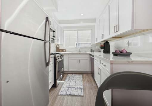 A kitchen with white appliances and cabinets.