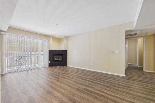 A spacious living room with a fireplace and sliding glass doors.