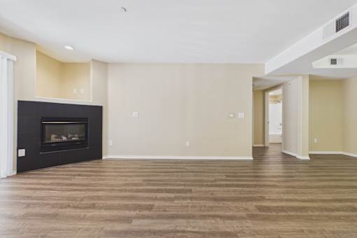 A living room with a fireplace and wood flooring.