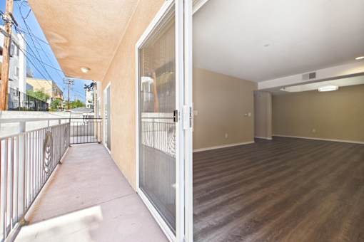 A balcony with a metal railing and a view of the street.