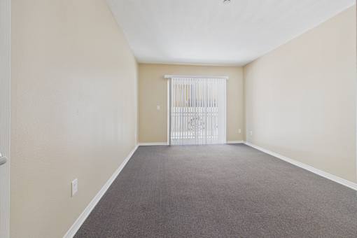 A room with a carpeted floor and a white door.
