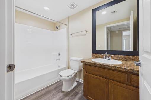 A bathroom with a toilet, sink, and shower.