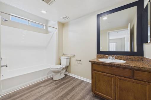 A bathroom with a white toilet and a white bathtub.