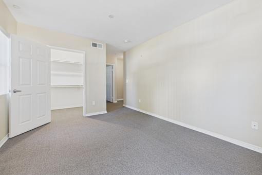 A room with a white door and carpeted floor.