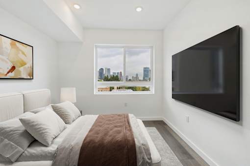 A bedroom with a large bed and a flat screen TV mounted on the wall.